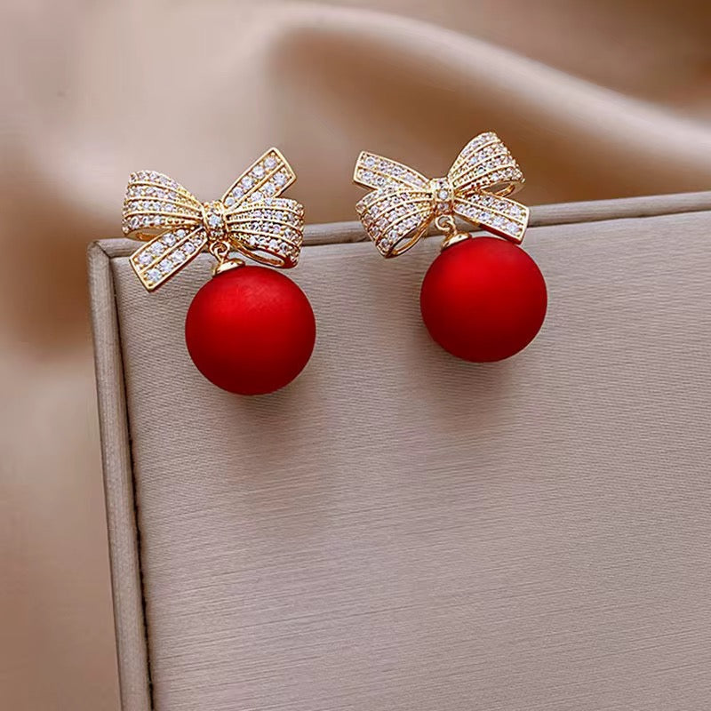 Boucles d'Oreilles "Nœud Étincelant" – Perles Rouges Satinées et Cristaux Pavés